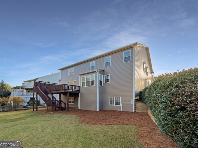 rear view of house with a lawn and a wooden deck