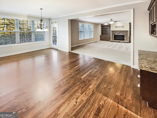 unfurnished living room with wood-type flooring, crown molding, and plenty of natural light