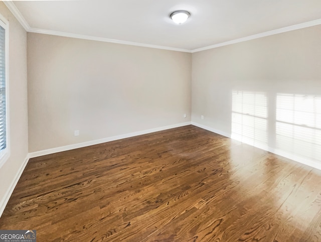 empty room featuring ornamental molding and dark hardwood / wood-style flooring