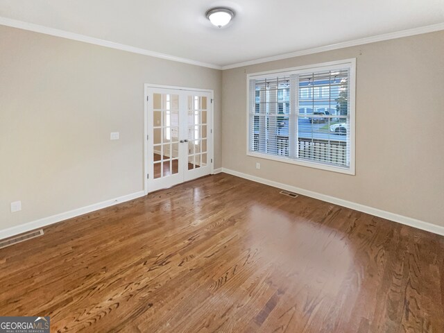 spare room with crown molding, french doors, and wood-type flooring