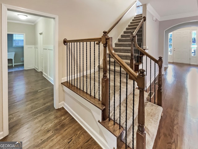 staircase featuring wood-type flooring and ornamental molding