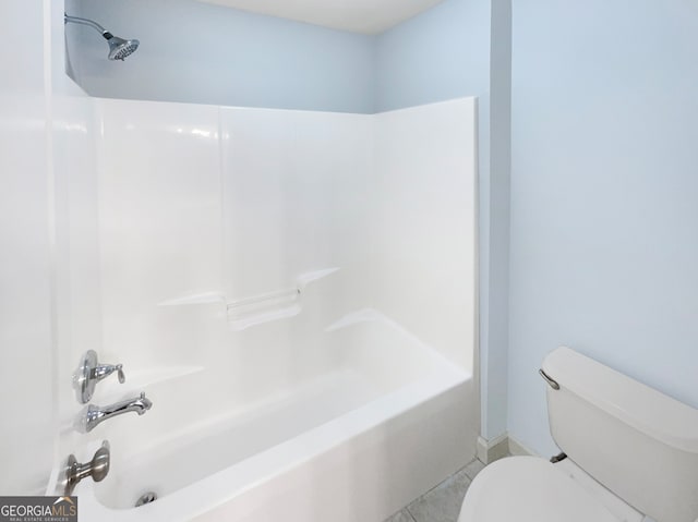 bathroom featuring tile patterned flooring, shower / bathing tub combination, and toilet