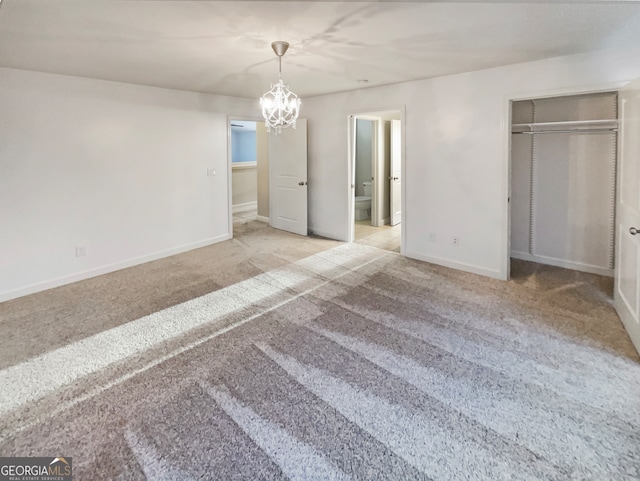 unfurnished bedroom with a closet, a notable chandelier, and light colored carpet