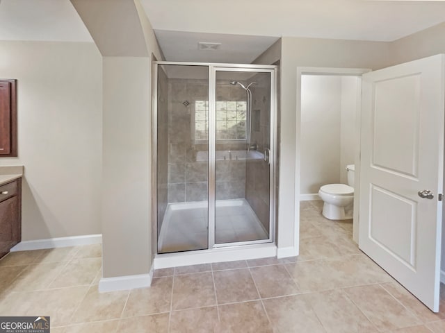 bathroom featuring tile patterned floors, vanity, toilet, and walk in shower