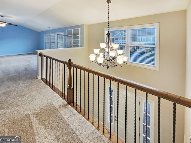 corridor featuring vaulted ceiling, carpet flooring, and an inviting chandelier