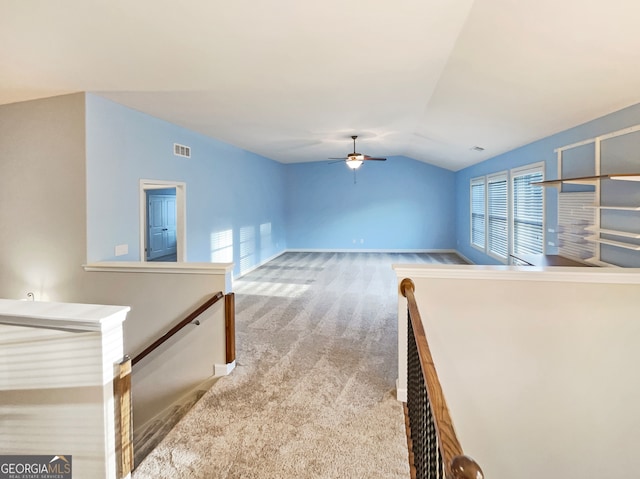 interior space featuring plenty of natural light, light colored carpet, and vaulted ceiling