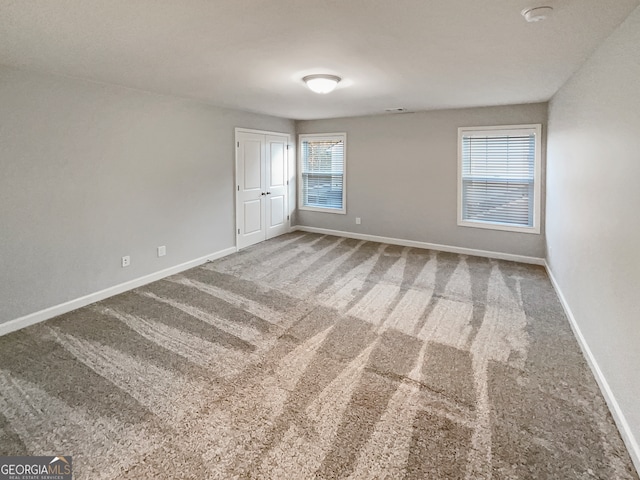 empty room featuring plenty of natural light and carpet