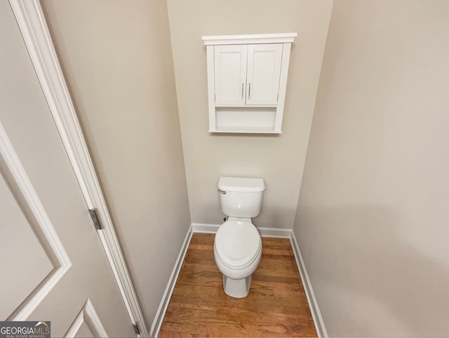 bathroom featuring hardwood / wood-style floors and toilet