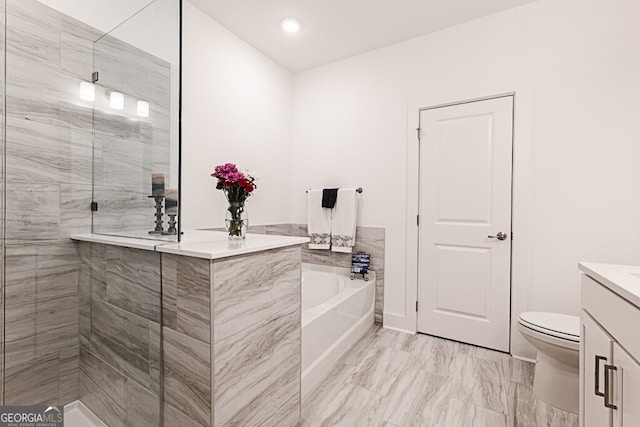 bathroom featuring a washtub, vanity, and toilet