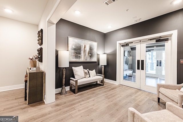 sitting room featuring french doors and light hardwood / wood-style flooring