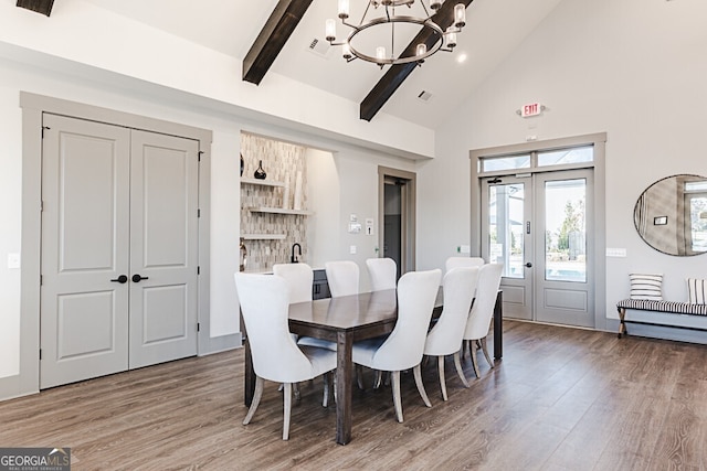 dining area with french doors, an inviting chandelier, beamed ceiling, high vaulted ceiling, and hardwood / wood-style flooring