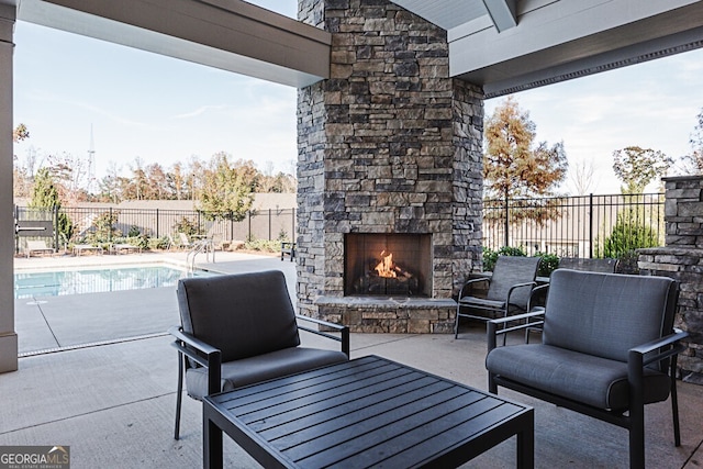 view of patio featuring a fenced in pool and an outdoor stone fireplace