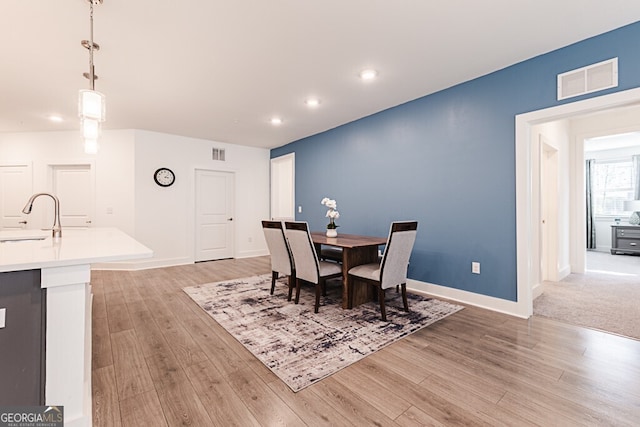 dining area with sink and light wood-type flooring