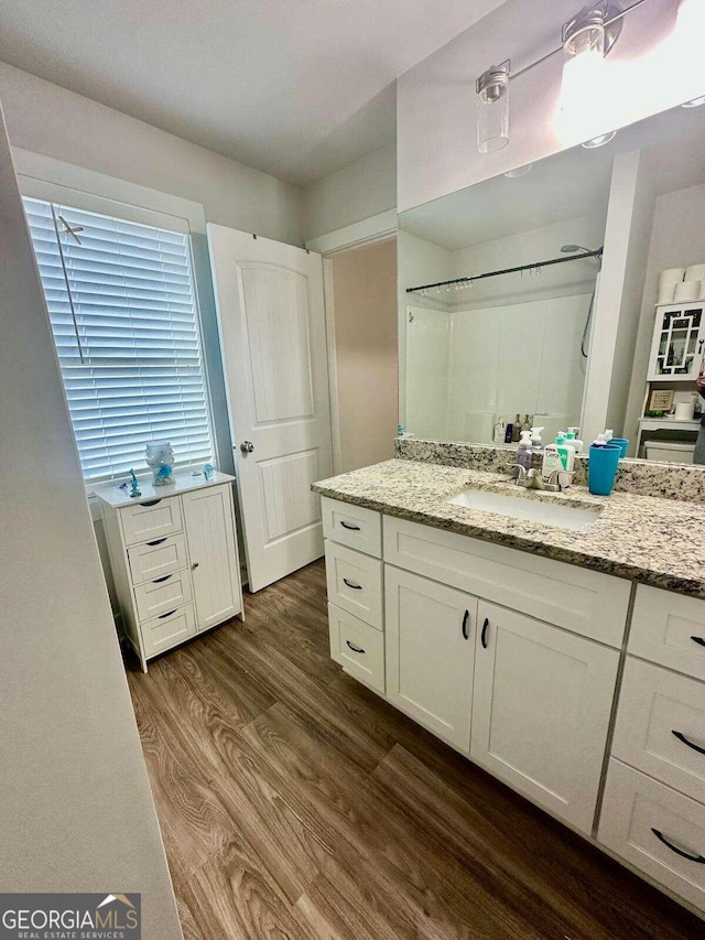 bathroom with vanity, wood-type flooring, and walk in shower