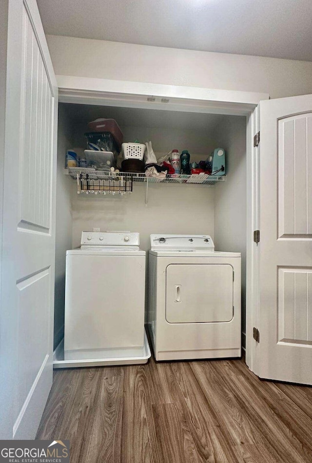 clothes washing area featuring washer and dryer and wood-type flooring