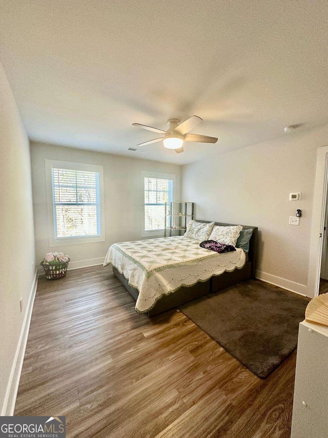 bedroom with ceiling fan, a textured ceiling, and hardwood / wood-style flooring