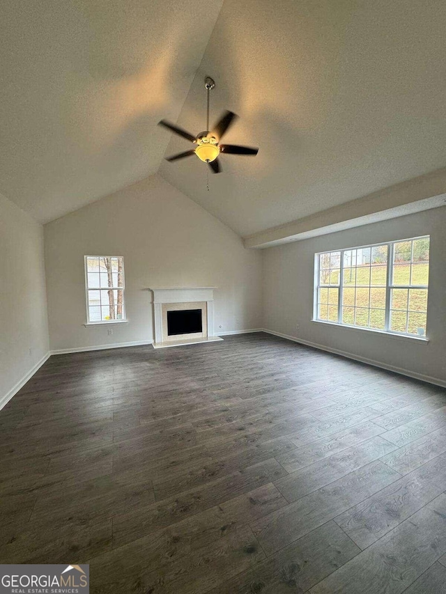 unfurnished living room with dark hardwood / wood-style flooring, ceiling fan, plenty of natural light, and lofted ceiling