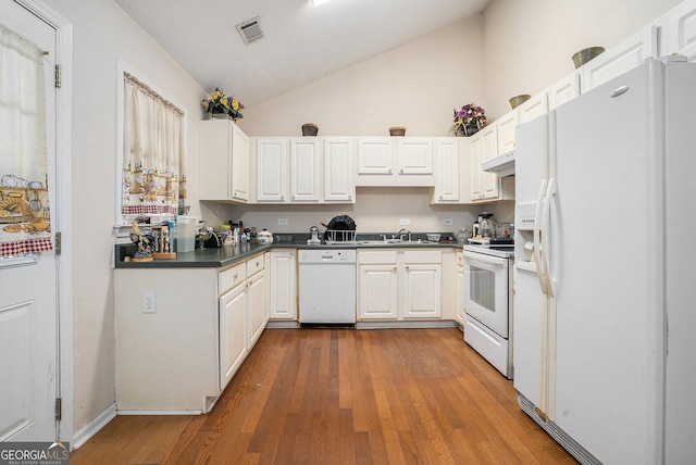 kitchen with white appliances, visible vents, dark countertops, lofted ceiling, and wood finished floors