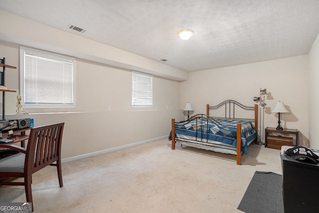 carpeted bedroom with a textured ceiling, visible vents, and baseboards