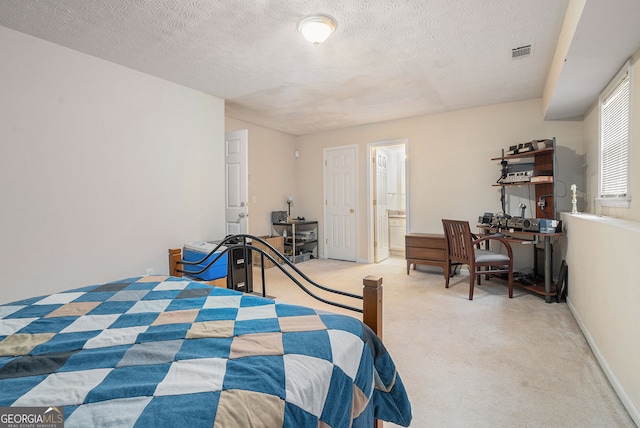 carpeted bedroom with a textured ceiling, ensuite bath, visible vents, and baseboards