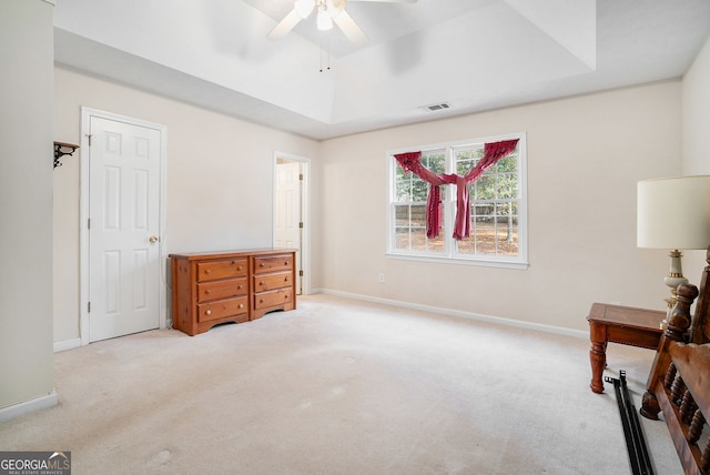 bedroom featuring carpet, visible vents, and a tray ceiling