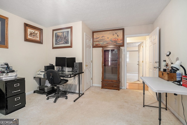 office featuring carpet, baseboards, and a textured ceiling