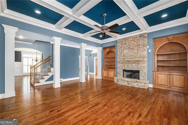 unfurnished living room with a fireplace, wood-type flooring, decorative columns, and ornamental molding