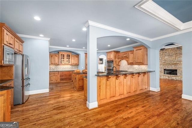 kitchen with decorative backsplash, crown molding, dark hardwood / wood-style flooring, and appliances with stainless steel finishes