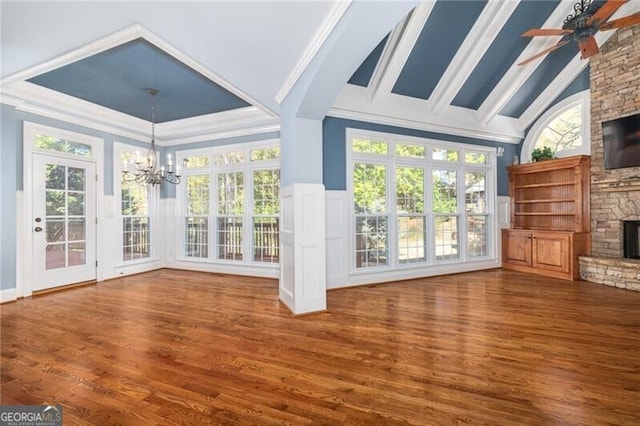 unfurnished sunroom with vaulted ceiling, ceiling fan with notable chandelier, and a stone fireplace