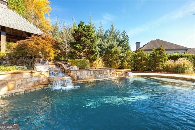 view of pool with pool water feature and a water view