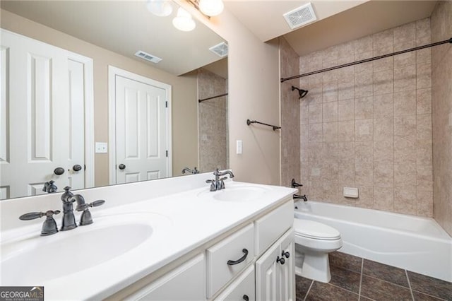 full bathroom with vanity, toilet, tiled shower / bath, and tile patterned floors