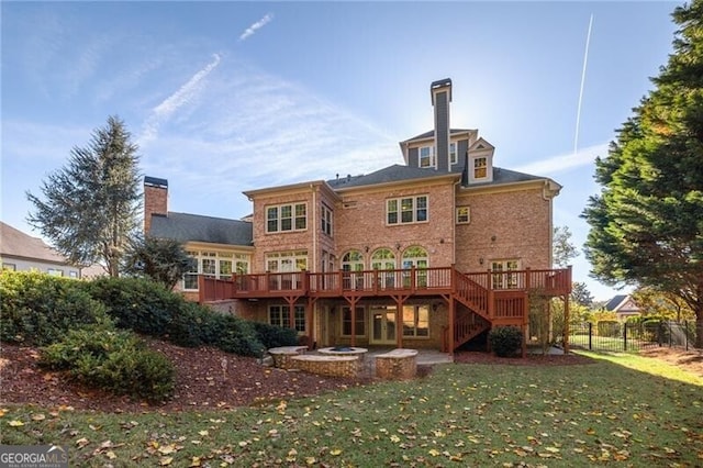 rear view of property featuring a yard and a deck