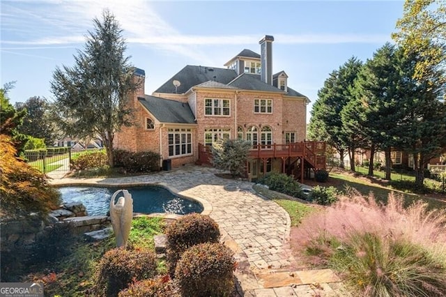 back of house featuring a swimming pool side deck