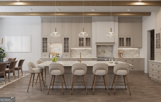 kitchen with a center island with sink, dark wood-type flooring, and decorative light fixtures