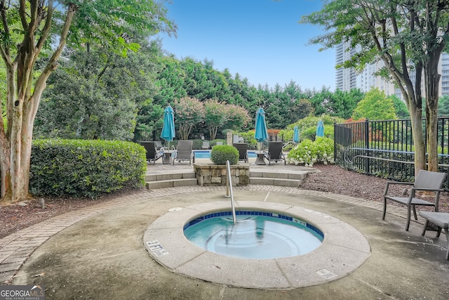 view of swimming pool with a patio area and a hot tub