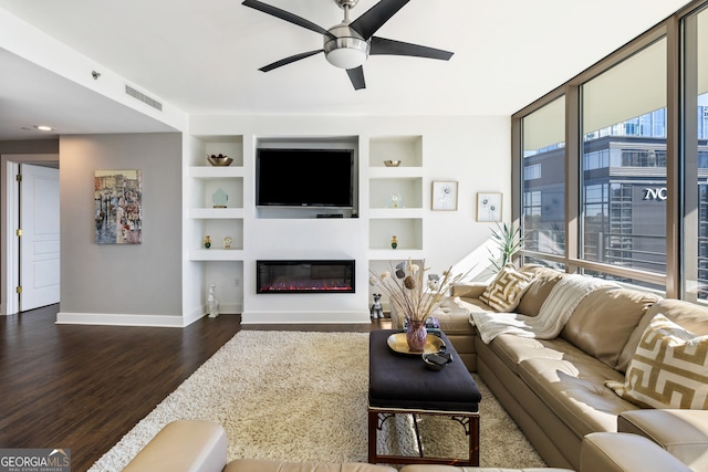 living room with built in features, ceiling fan, and dark wood-type flooring