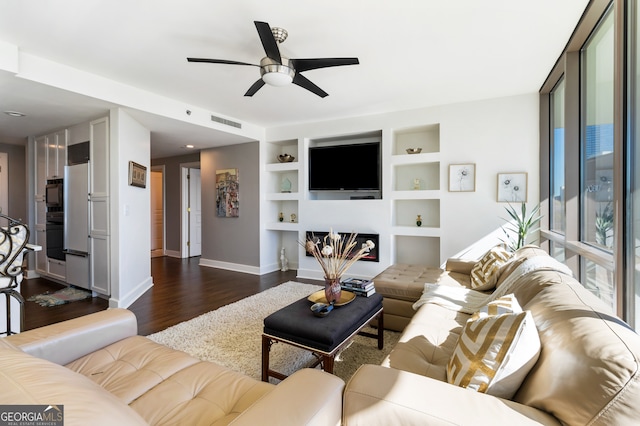 living room with dark hardwood / wood-style floors, built in features, and ceiling fan