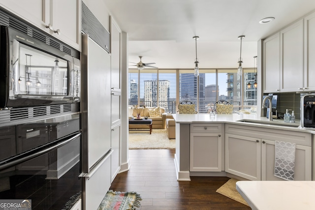 kitchen with dark hardwood / wood-style flooring, tasteful backsplash, black appliances, white cabinetry, and hanging light fixtures