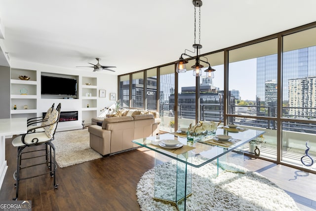 interior space with dark hardwood / wood-style floors, ceiling fan, floor to ceiling windows, and built in shelves