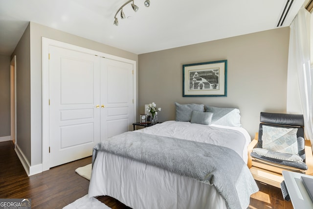 bedroom with dark hardwood / wood-style flooring and a closet