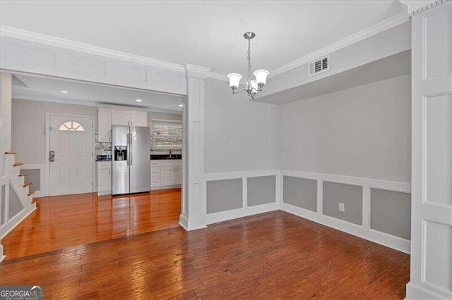 unfurnished dining area with crown molding, sink, and wood-type flooring