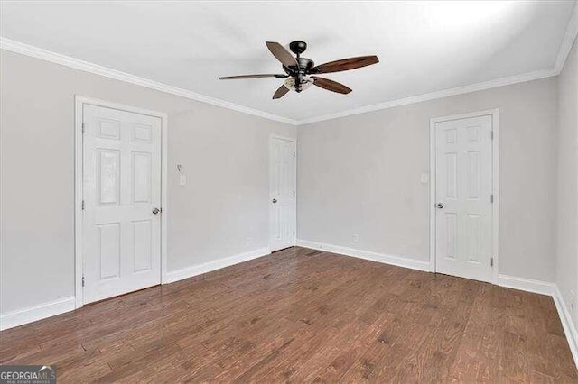 empty room featuring ornamental molding, ceiling fan, and dark wood-type flooring