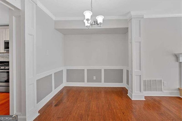 unfurnished dining area featuring a chandelier, crown molding, and wood-type flooring