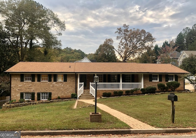 single story home featuring covered porch and a front yard