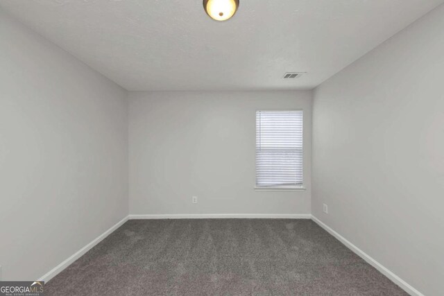 empty room with dark colored carpet