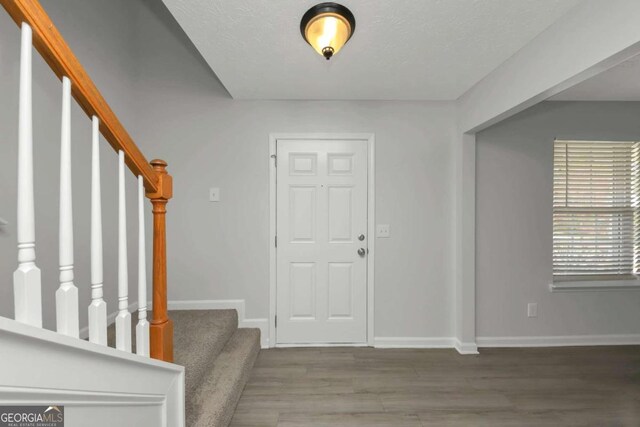 foyer featuring hardwood / wood-style floors and a textured ceiling