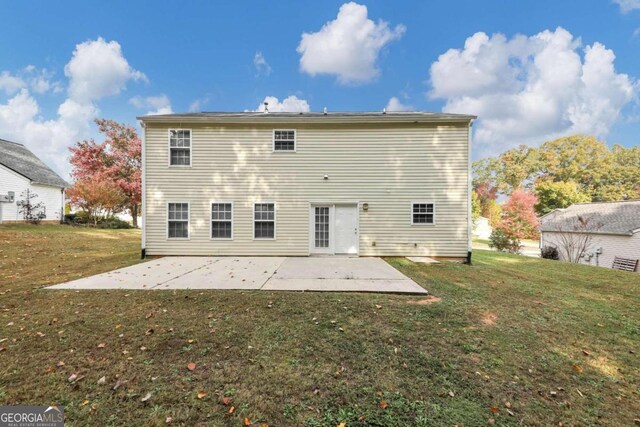 back of property with a yard and a patio