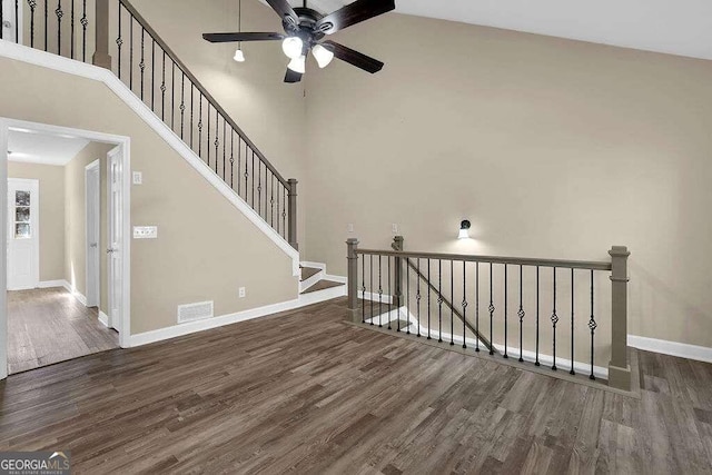 stairway featuring high vaulted ceiling, ceiling fan, and hardwood / wood-style flooring