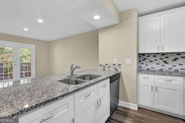 kitchen featuring tasteful backsplash, dark wood-type flooring, sink, dishwasher, and white cabinetry