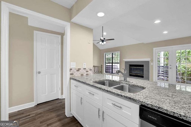 kitchen featuring white cabinetry, dishwasher, sink, and light stone counters